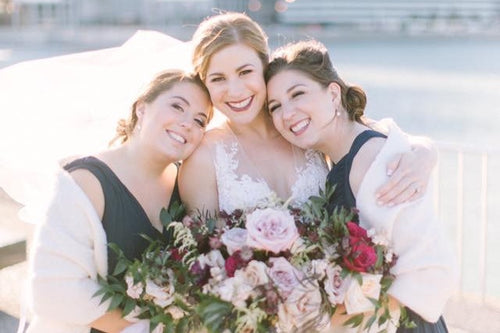 Bride and bridesmaids sharing a joyful moment, all makeup done by Glamour Girl
