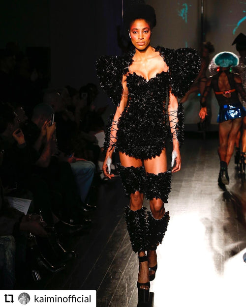 Glamour Girl Airbrush Tan features a model in a black embellished dress with bold makeup at NYFW.
