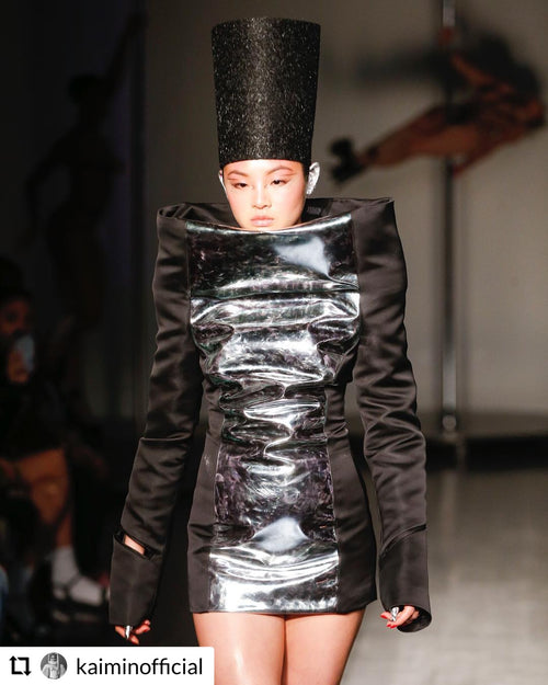 Glamour Girl Airbrush Tan's avant-garde makeup on a model in a silver outfit at NYFW.