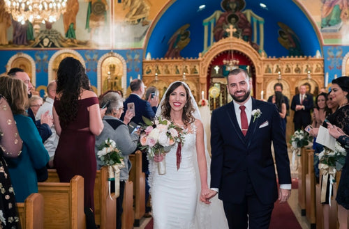 Bride and groom walking down the aisle in church with bride featuring Glamour Girl makeup