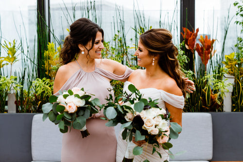 Bride embracing bridesmaids with Glamour Girl makeup, joyous expressions