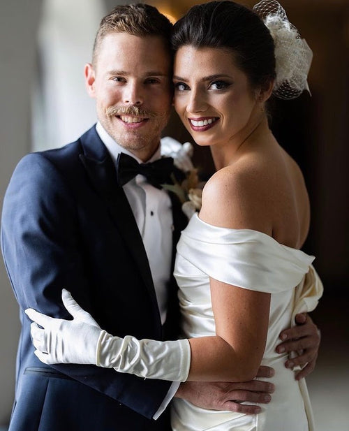 Couple embracing on their wedding day, showcasing their spray tans from Glamour Girl Airbrush Tan in Chicago.