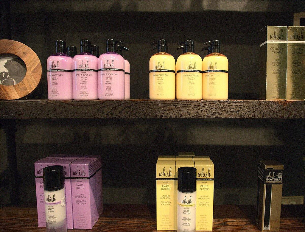Image of a wooden retail shelving display showcasing various skincare products, including Whish Body Butter, offering customers a range of options for pampering and self-care