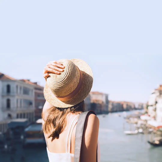 Image featuring a woman showcasing her perfect spray tan, wearing a vacation hat, while on holiday.
