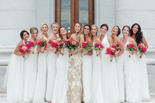 Group of bridesmaids in white gowns holding floral bouquets with Glamour Girl makeup in Chicago