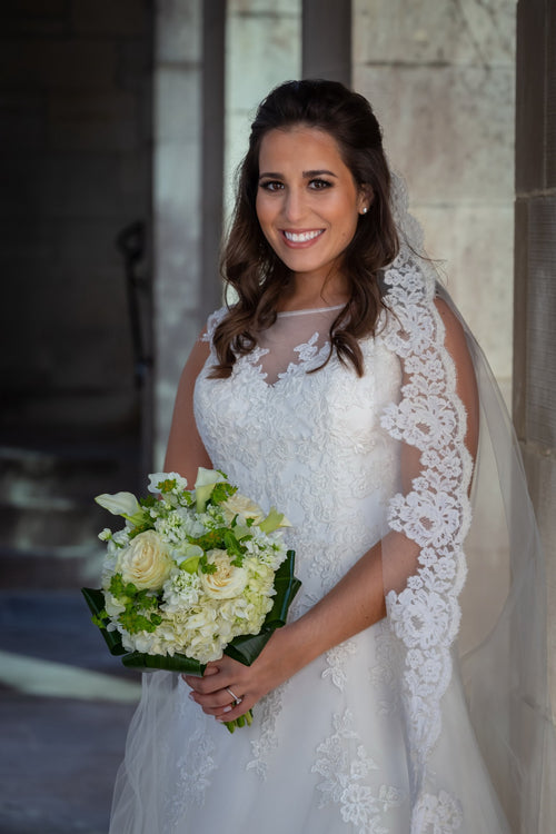 Elegant bridal portrait featuring Glamour Girl makeup, with a bouquet