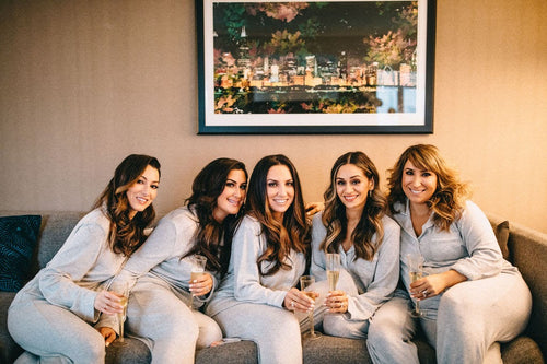 Bachelorette party in matching loungewear, enjoying a toast in a Chicago home, all featuring Glamour Girl Airbrush Tans.