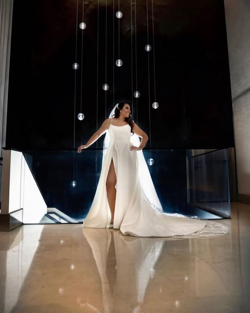 A modern bride in a chic white gown, standing in a contemporary Chicago venue, her look completed with a Glamour Girl Airbrush Tan.