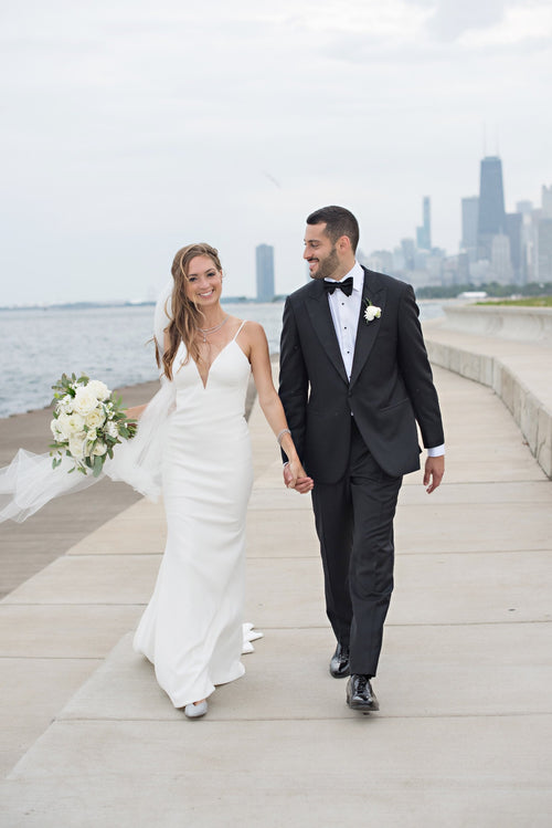 Bride and groom walking by the lake with Chicago skyline in the background, bride styled by Glamour Girl