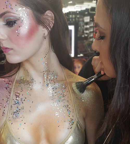 Makeup artist from Glamour Girl Airbrush Tan applying glitter for a dazzling makeup look in Chicago