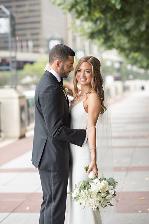 Intimate moment of the bride and groom embracing in the city, with Glamour Girl makeup